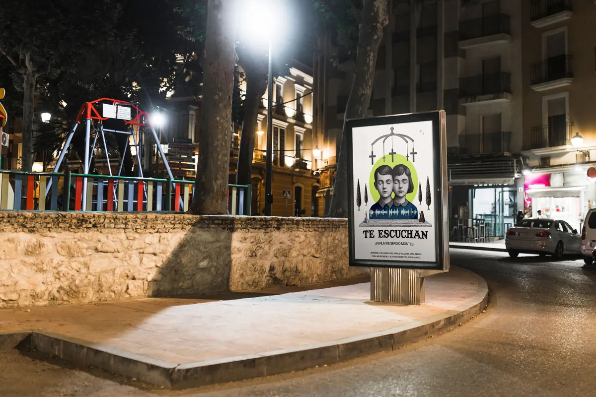Cartel de Te escuchan colocado en un soporte urbano